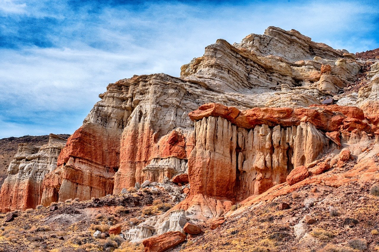 Wide shot of the Mojave Desert with a futuristic drone hovering above red rocks, sunlight creating a hazy effect, NASA logo subtly visible in the corner, alt text: Mars drone testing in the Mojave Desert